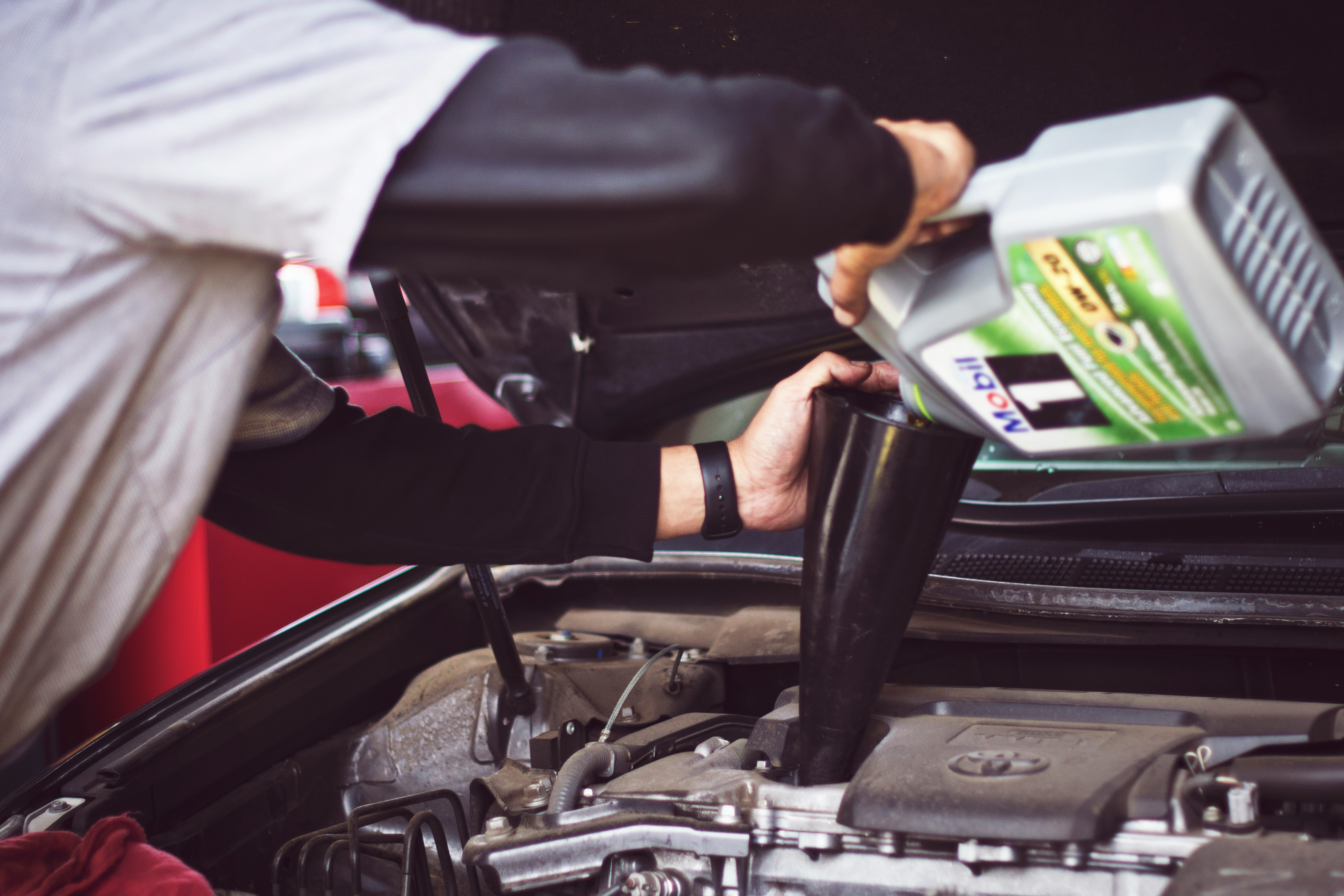 Mechanic pouring oil into an engine
